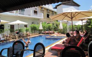 a group of people sitting around a swimming pool at Blossoming Romduol Boutique in Siem Reap