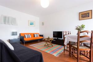 a living room with a couch and a table at Cegonha do mar in Aljezur