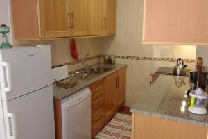 a kitchen with a white refrigerator and a sink at Cegonha do mar in Aljezur +7 photos