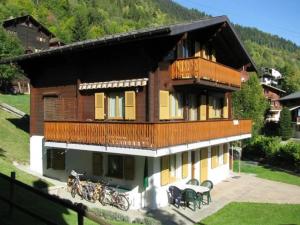a house with a balcony with bikes parked in front of it at Ferienwohnung Duinli in Fiesch