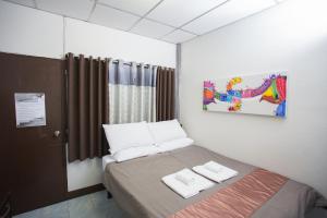 a bedroom with a bed with two towels on it at Zzhouse in Chiang Mai