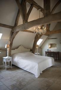 een slaapkamer met een groot wit bed en een kroonluchter bij Auberge 's Gravenhof in Voeren