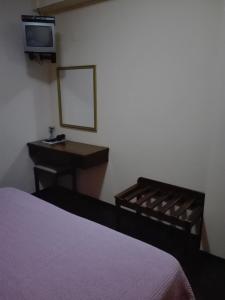 Schlafzimmer mit einem Bett, einem Schreibtisch und einem Spiegel in der Unterkunft Estalagem Corte do Norte in Ponta Delgada