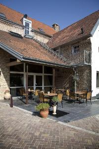 a patio with tables and chairs in a building at Auberge 's Gravenhof in Voeren