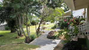 a walkway leading to a house with palm trees at Beau Vallon Bungalows in Beau Vallon