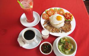 a red table with a plate of food and a cup of coffee at Blossoming Romduol Boutique in Siem Reap