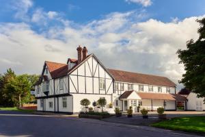 a large white house with a roof at Mercure Thame Lambert Hotel in Chinnor