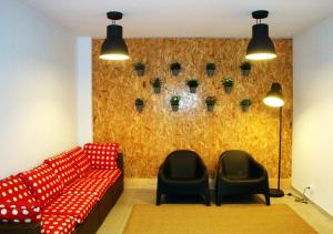 uma sala de espera com um sofá vermelho e duas cadeiras em Parque de Campismo Orbitur Caminha em Caminha