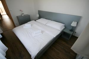 a large bed with white sheets and pillows at Apartmány Apollon Resort Lednice in Lednice
