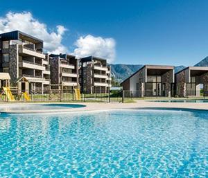 a large swimming pool in front of some buildings at Casa en Condominio Costa Pucón in Pucón