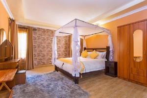 a bedroom with a bed with a canopy at Nokras Riverine Hotel & Spa in Sagana