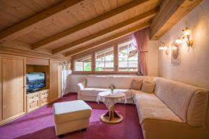 a living room with a couch and a tv at Ferienhaus Elisabeth in Ellmau