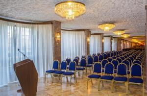 a conference room with blue chairs and a podium at Hotel Plaza in Taranto