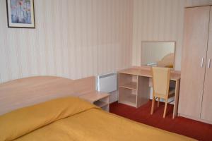 1 dormitorio con cama, escritorio y mesa en Vila Evelina, en Druskininkai