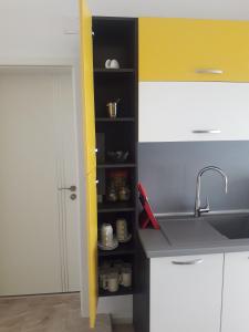 a kitchen with a sink and a shelf with cups at Shishkova 3 Apartment in Varna City