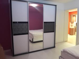 a mirror in a bedroom with a bed in a room at Shishkova 3 Apartment in Varna City