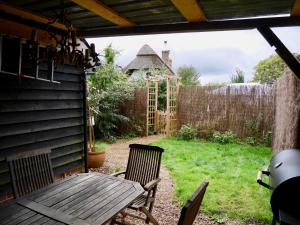 a backyard with a wooden bench and a greenhouse at Wayside Cottage in Beaulieu