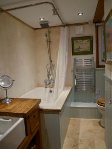 y baño con bañera, lavabo y aseo. en Wayside Cottage en Beaulieu