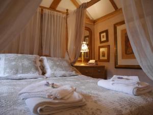 a bedroom with a bed with towels on it at Wayside Cottage in Beaulieu