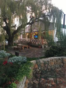 a park with a bench and a tree and a building at Riverview Country Inn in Van Reenen