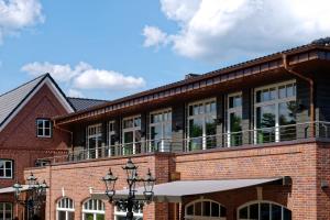 a brick building with a balcony on top of it at Hotel Sellhorn, Ringhotel Hanstedt in Hanstedt