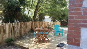 d'une terrasse avec une table, des chaises et une clôture. dans l'établissement STUDIO 300m DE LA PLAGE, à Soulac-sur-Mer