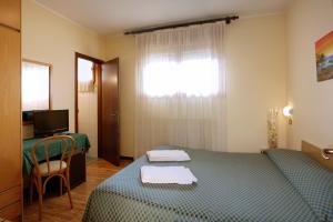una camera con letto, scrivania e finestra di Hotel Agli Olmi a San Biagio di Callalta