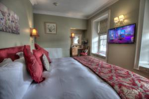 a bedroom with a large bed and a television at Dunster Castle Hotel in Dunster