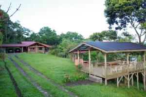 a wooden gazebo in a yard with a house at Finca Tres Equis - Farm and Forest in Tres Equis