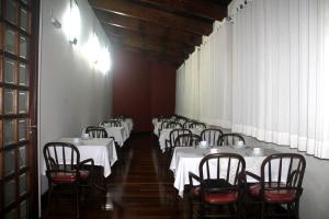 a row of tables and chairs in a room with white table cloth at Ancelf Express in Palmas