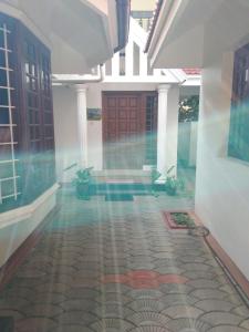 un couloir d'une maison avec une porte et quelques plantes dans l'établissement Birds Nest Home Stay, à Cochin