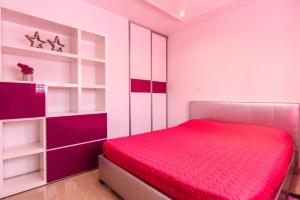 ein Schlafzimmer mit einem roten Bett und weißen Regalen in der Unterkunft Apartments Gea in Trogir