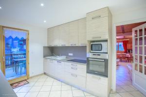 uma cozinha com armários brancos e um micro-ondas em Chalet Bellevue em La Chapelle-dʼAbondance