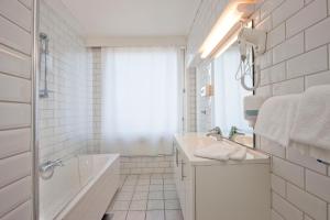 a white bathroom with a tub and a sink at Hotell Vic Porsgrunn in Porsgrunn +38 photos