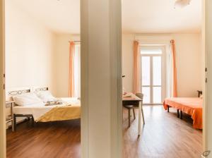 a bedroom with a bed and a desk in a room at Attico con 2 camere in Via Vespucci in Viareggio