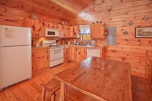 a wooden kitchen with a table and a refrigerator at Mountain Seclusion in Sevierville