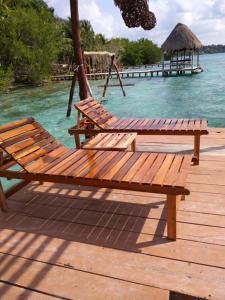 a wooden bench sitting on top of a wooden pier at Villas Eco-Románticas Kúuch Ka´anil in Bacalar