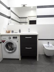 a bathroom with a washing machine and a sink at IRIS apartments in Odesa