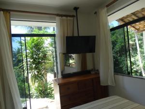 a bedroom with a bed and a television and windows at Casa Parque de Olivenca in Pontal