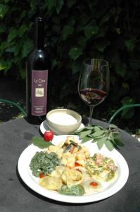 un plato de comida con una botella de vino y una copa en Osteria Locanda Brack, en Gudo
