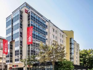 ein Gebäude mit roten Schildern an der Seite in der Unterkunft ibis Augsburg Hauptbahnhof in Augsburg
