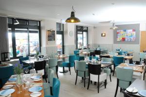 a dining room with tables and blue chairs at Seascale Hotel & Restaurant in Gorey