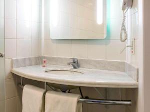 a bathroom with a sink and a mirror and towels at ibis Araçatuba in Araçatuba