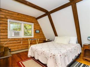 a bedroom with a bed in a room with wooden walls at Eagle's Rest Lodge in Hendersonville