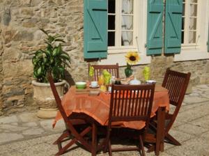 a table with two chairs and a table with a tableablish at Domaine Saint Andrieu in Greffeil