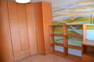 Habitación con armarios de madera y una pintura en la pared. en La Verdevilla en Anguix
