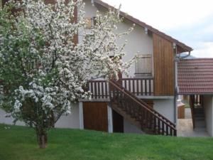 une maison avec un arbre planté de fleurs blanches dans l'établissement Duplex Bellevue, à Gérardmer