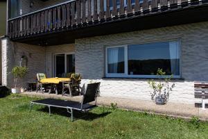 a patio with a table and chairs in front of a house at Apartment Bellevue in Blieskastel