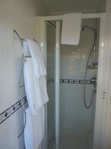 y baño con ducha y toallas blancas. en Maes-y-Garth, en Betws-y-coed