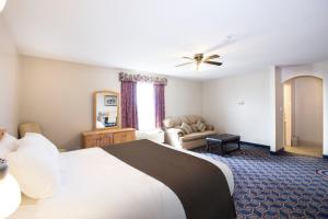 une chambre d'hôtel avec un lit et un canapé dans l'établissement West Country Inn, à Drayton Valley